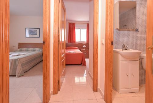 a bathroom with a bed and a sink in a room at Apartamentos Marblau Peredamar-Julio y Agosto SOLO FAMILIAS in Gandía