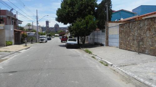 an empty street with cars parked on the side of the road at Casa e Suites in Aparecida