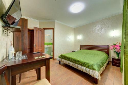 a bedroom with a green bed and a desk at Лика Отель in Kyiv