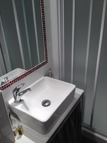 アジャクシオにあるStudio centre ville Ajaccioのバスルーム(白い洗面台、鏡付)