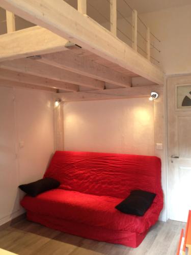 アジャクシオにあるStudio centre ville Ajaccioのロフト付きの部屋の赤いベッド1台