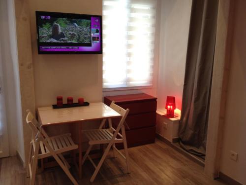 アジャクシオにあるStudio centre ville Ajaccioのテーブルと壁掛けテレビ付きの小さな部屋