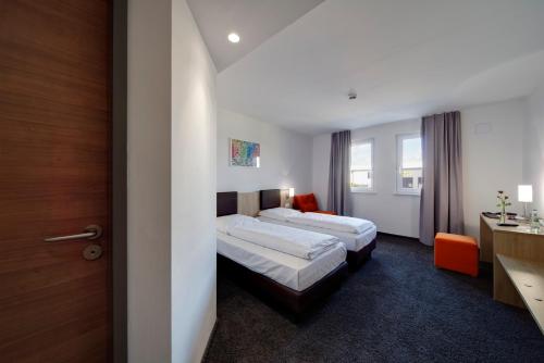 フリートベルクにあるEuro Hotel Friedbergのベッド2台とデスクが備わるホテルルームです。