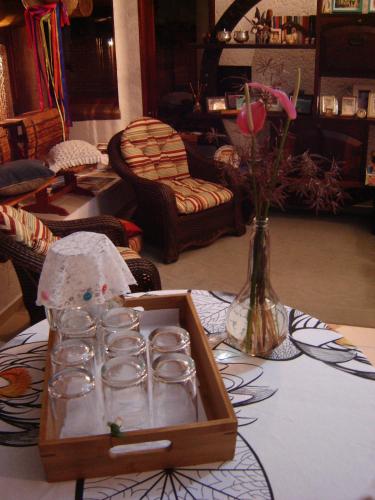 a tray of glasses on a table with a vase at Pousada Preamare in Ubatuba