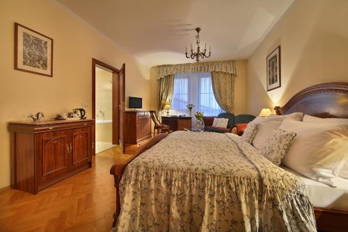 a bedroom with a large bed and a living room at Boutique Hotel Constans in Prague