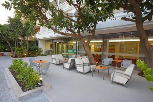 a restaurant with tables and chairs in front of a building at Olympic Palladium in Rethymno Town