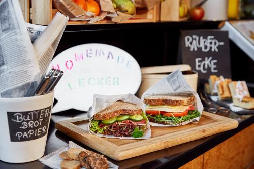 two sandwiches on a cutting board on a table at Lindner Hotel Cologne Am Dom, part of JdV by Hyatt in Cologne