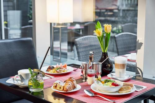 a table with two plates of food on it at Lindner Hotel Cologne Am Dom, part of JdV by Hyatt in Cologne