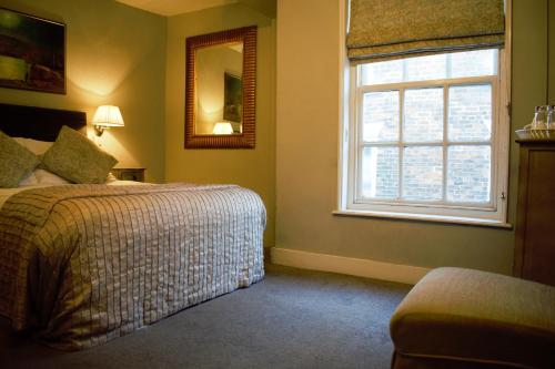 a bedroom with a bed and a window and a mirror at White Horse & Griffin in Whitby
