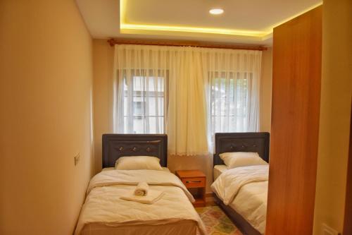 a bedroom with two beds and a window at Badul Apart in Uzungöl