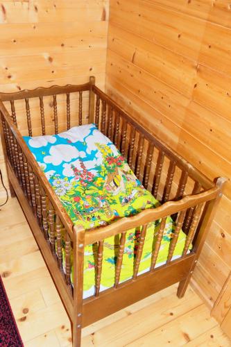 a wooden crib with a colorful blanket on it at Landhaus Tenne in Bartholomäberg
