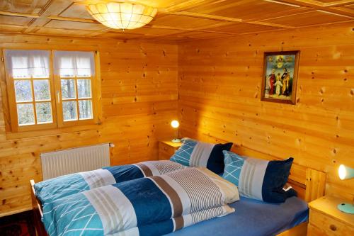 1 dormitorio con 1 cama en una cabaña de madera en Landhaus Tenne, en Bartholomäberg