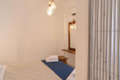 a room with a bed with a blue rug and a mirror at Santorini Crystal Blue Boutique Hotel in Kamari