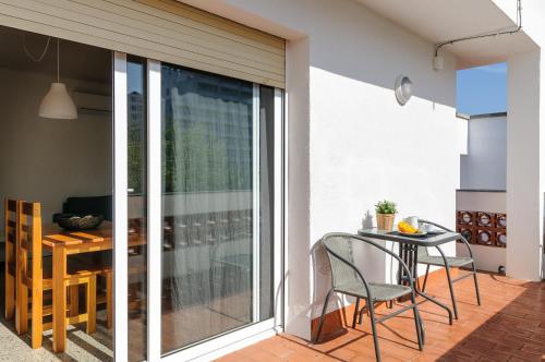 Una habitación con balcón con mesa y sillas. en Empuriabrava Apartaments - nº 10, en Empuriabrava