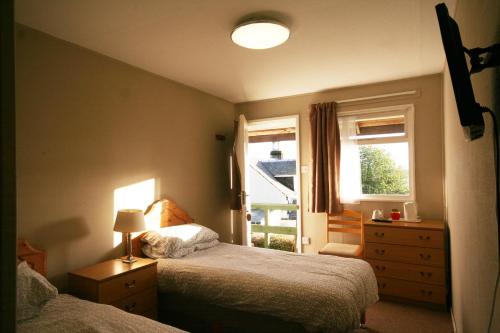 a bedroom with two beds and a window at The Arran Lodge & Arran Sleep Huts in Lamlash
