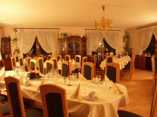 a dining room with tables and chairs with white table cloth at Waldpension zum Felsenkeller in Lichtenfels-Sachsenberg