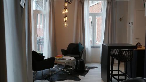 a living room with chairs and a table and windows at PortaNova 21 in Huy