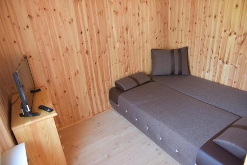 a small bedroom with a bed in a wooden room at Djuna Majori in Jūrmala