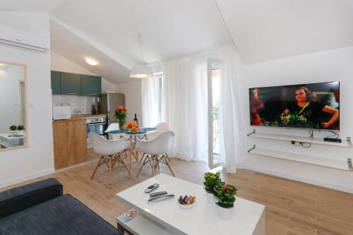 uma sala de estar com uma grande televisão na parede em Apartments and Rooms Stone House em Split