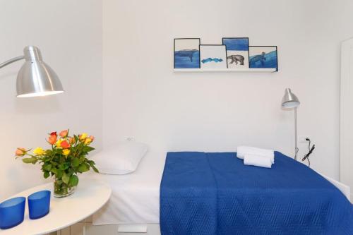 a white room with a blue bed and a table at Apartments and Rooms Stone House in Split