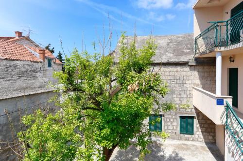 a tree in front of a building at Apartments and Rooms Stone House in Split