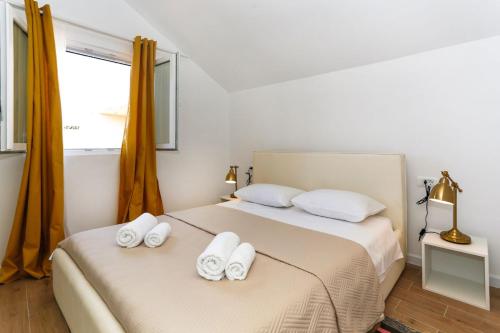 a bedroom with two beds with towels on them at Apartments and Rooms Stone House in Split