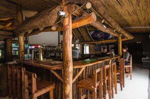 a bar in a restaurant with wooden tables and chairs at Du Kloof Lodge in Paarl