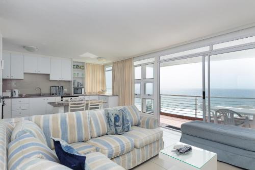 a living room with a couch and a view of the ocean at Chakas Cove 39 in Ballito