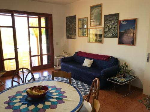 - un salon avec un canapé bleu et une table dans l'établissement Villa Gisira, à Augusta