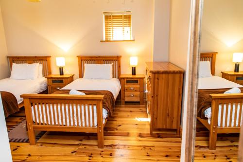 um quarto com duas camas e duas lâmpadas em duas mesas em Piper's Chair Houses em Doolin