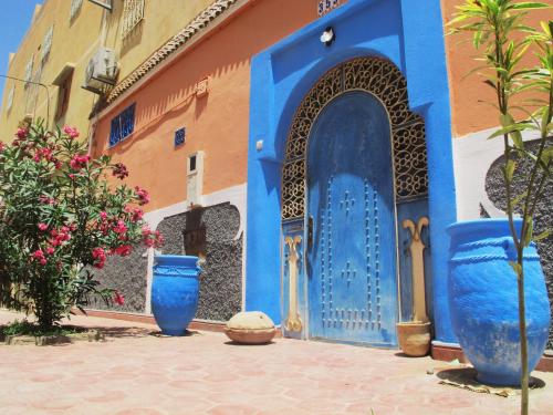dwa niebieskie wazy siedzące przed budynkiem w obiekcie Riad De Rêve w mieście Zakura