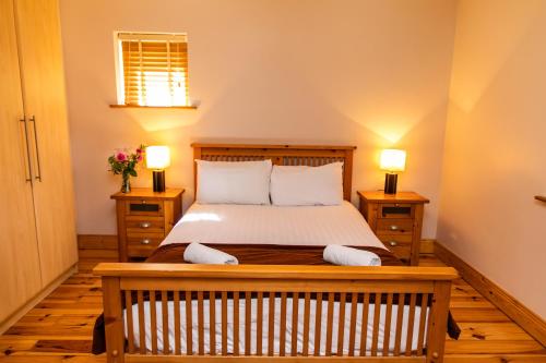 a bedroom with a bed with two night stands and two lamps at Hotel Doolin Houses in Doolin
