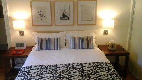 a bedroom with a bed with two lamps and two pillows at Beaune City Suite in Beaune