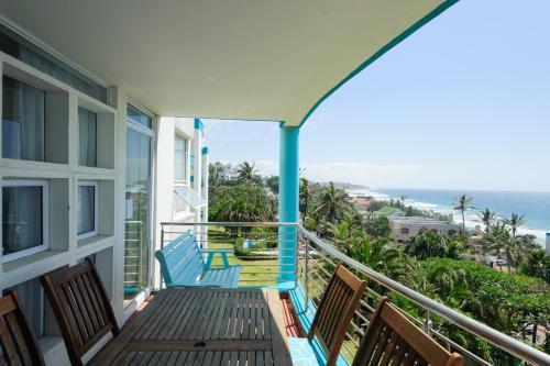 a balcony with two blue chairs and the ocean at Chakas Cove 94 in Ballito