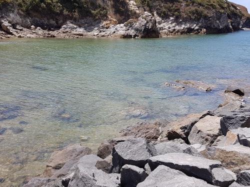 a group of rocks on the shore of a body of water at Chalé da Baía in Porto Covo
