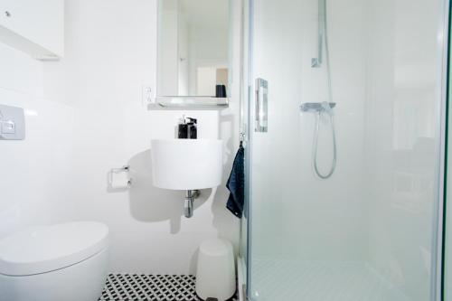 レバルにあるResort Apartamenty Klifowa Rewal 4の白いバスルーム(シャワー、トイレ付)