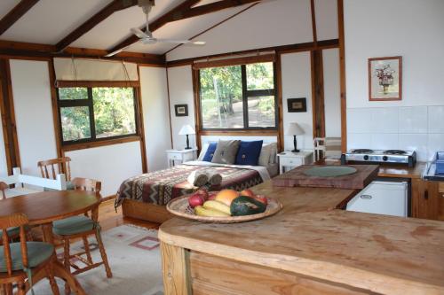 um quarto com uma cama e uma mesa com uma tigela de fruta em Treehouse Cottage em The Crags
