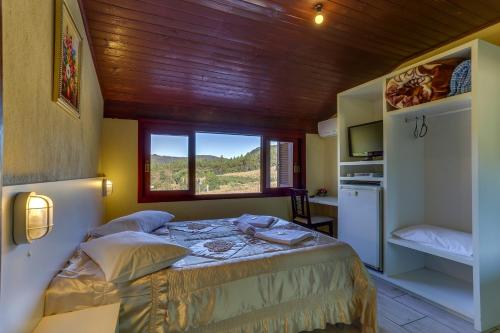 a bedroom with a bed in a room with a window at Pousada Tio Mica in Nova Petrópolis