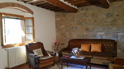 a living room with a couch and a chair at Colonica Montebeni in Greve in Chianti
