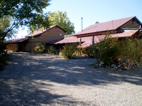 a house with a driveway next to a building at Silver River Adobe Inn Bed and Breakfast in Farmington