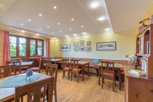 a dining room with wooden tables and chairs at Pension Zum Ebenstein am Donausteig in Untergriesbach