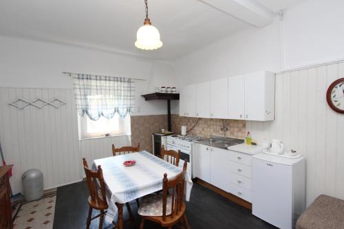 kuchnia ze stołem i krzesłami oraz kuchnia z białymi szafkami w obiekcie Apartments Rosanna w Rovinj