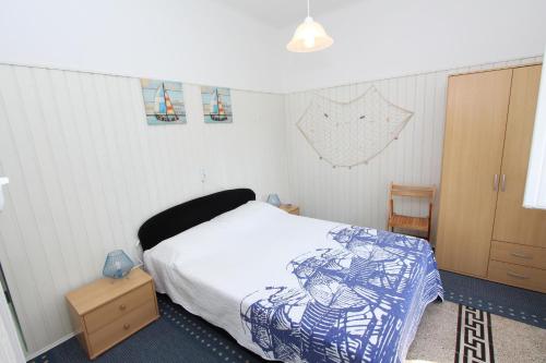 sypialnia z łóżkiem i drewnianą szafką w obiekcie Apartments Rosanna w Rovinj