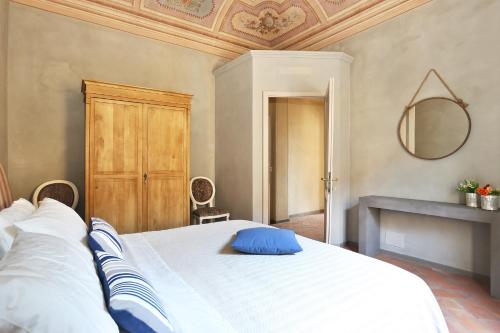 Un dormitorio con una cama con una almohada azul. en Tuscania Apartments, en Santa Croce sull'Arno