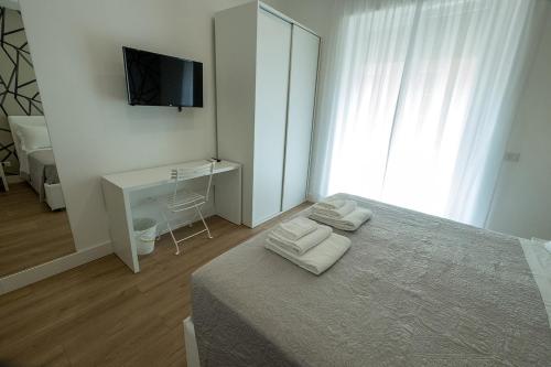 a bedroom with a bed and a desk and a television at Suite Pinturicchio in Rome