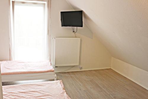 Zimmer mit einem Bett, einem TV und einem Fenster in der Unterkunft Dornfelder in Hanhofen