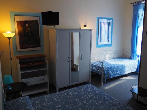 a bedroom with a bed and a cabinet with a mirror at hotel albatros in Arenzano