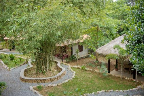 a garden with a house and a tree at Khmer Hands in Kep