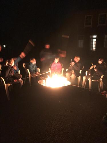 a group of people sitting around a fire in the dark at Ferienhof Utech in Wenkendorf auf Fehmarn