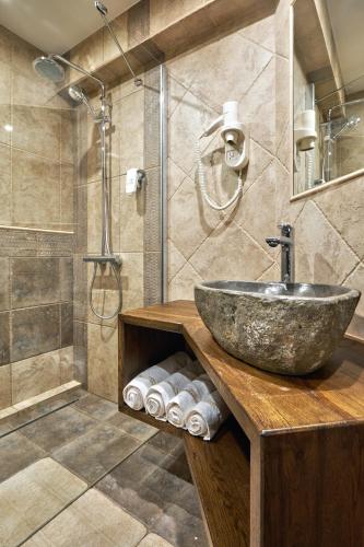 a bathroom with a stone sink and a shower at Villa Arbanashki Han in Arbanasi